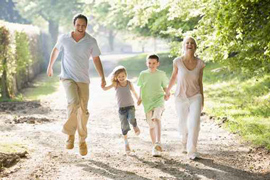 Zdjęcie przedstawiające spacerującą uśmiechniętą rodzinę